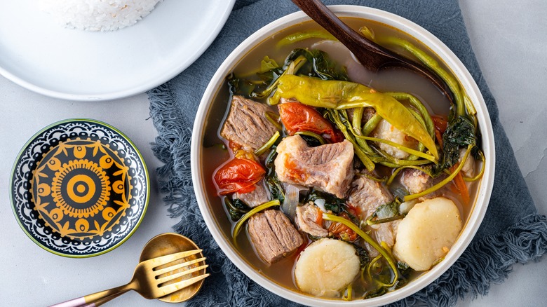 Bowl of sinigang soup with wooden spoon