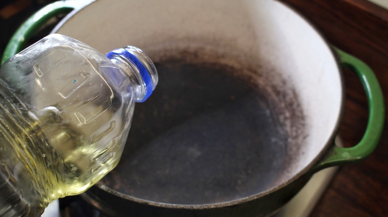 adding vegetable oil to pot