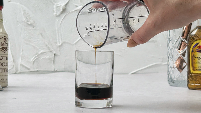 Pouring kahlúa into glass
