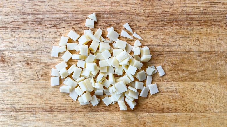 Provolone cut into small squares on cutting board