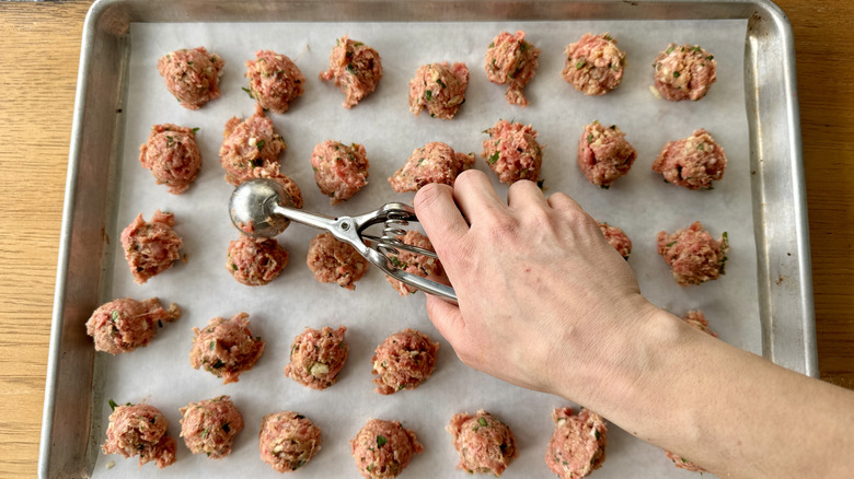 hand using metal scoop to portion out ground meat