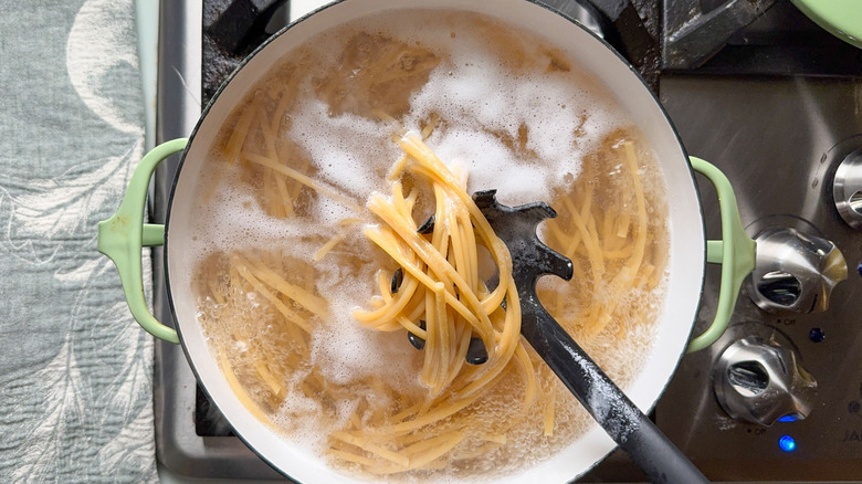 Chickpea spaghetti cooking in pot on stove