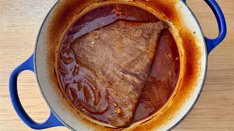 Cooked brisket and sauce in Dutch oven