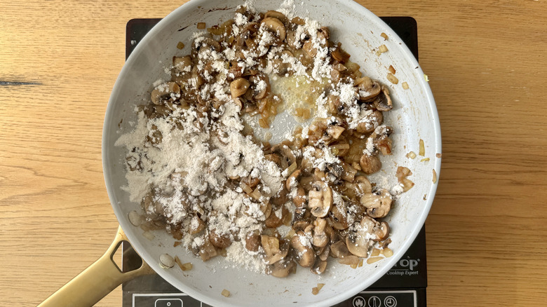 Adding flour to mushrooms in skillet