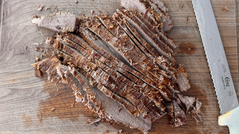 Sliced brisket on cutting board with knife