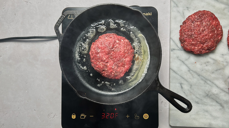 cooking burger in skillet