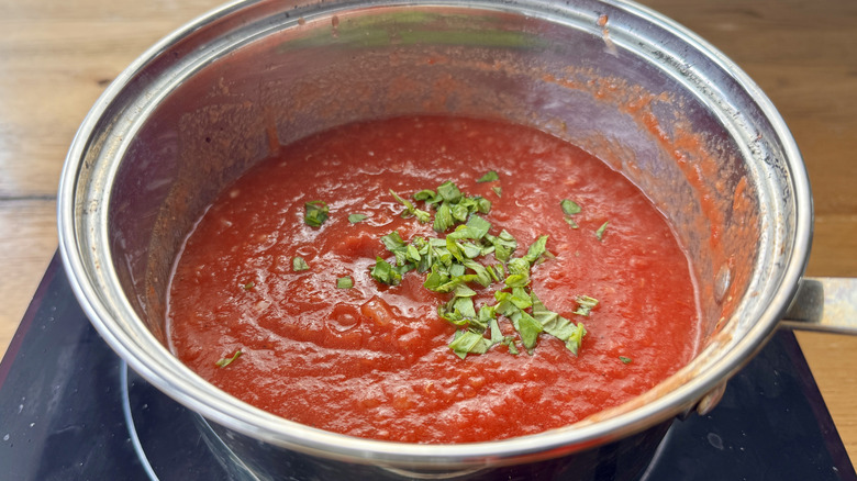 tomato sauce and basil in a metal pot