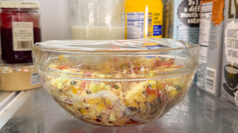 Panzanella salad in glass bowl in refrigerator