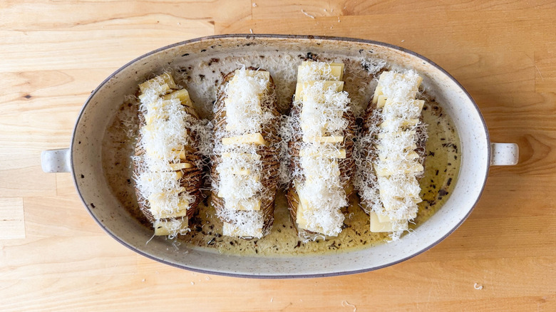 Hasselback potatoes filled with cheese slices and grated parmesan