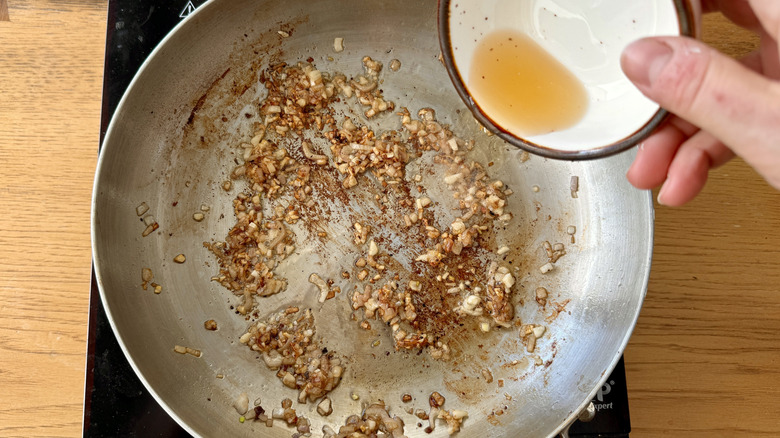 pouring hserry into skillet with mushrooms and shallots