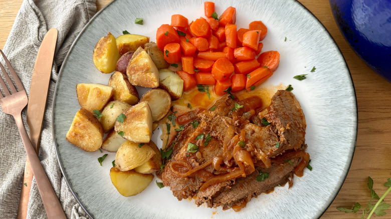 Brisket, carrots, and roasted potatoes on plate
