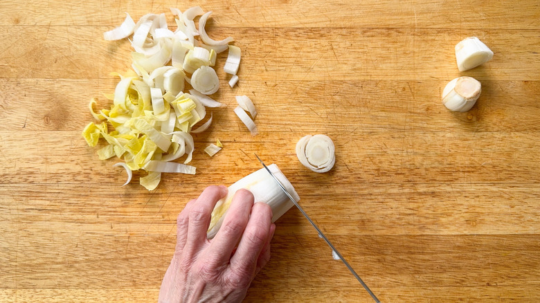 Slicing Belgian endive into rounds on cutting board