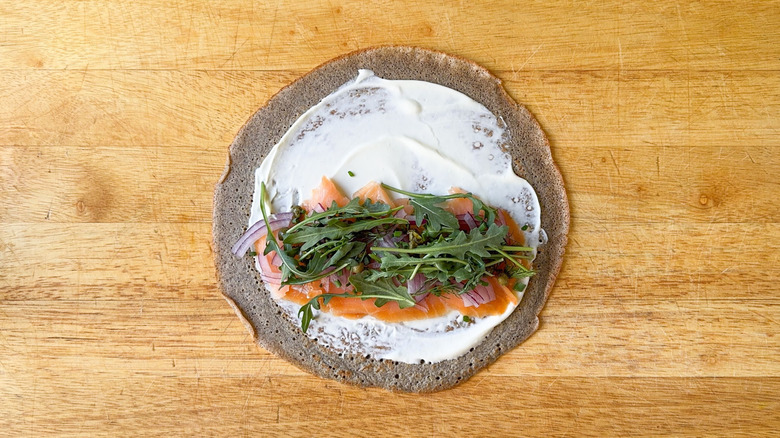 Buckwheat crepe with creme fraiche, smoked salmon, red onion, capers, dill fronds, chives, and arugula