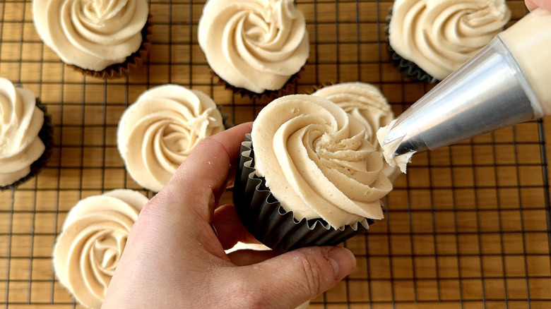 Frosting cupcakes with piping bag