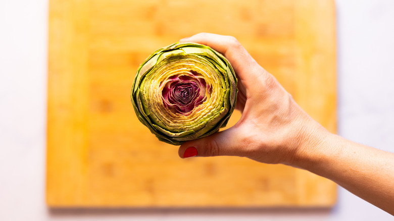 hand holding trimmed artichoke, view of center