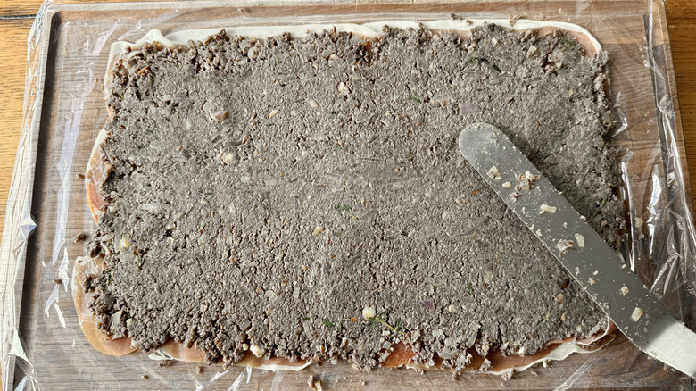 spreading mushroom duxelles over prosciutto