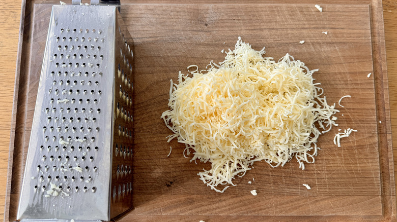 Shredded cheese on cutting board