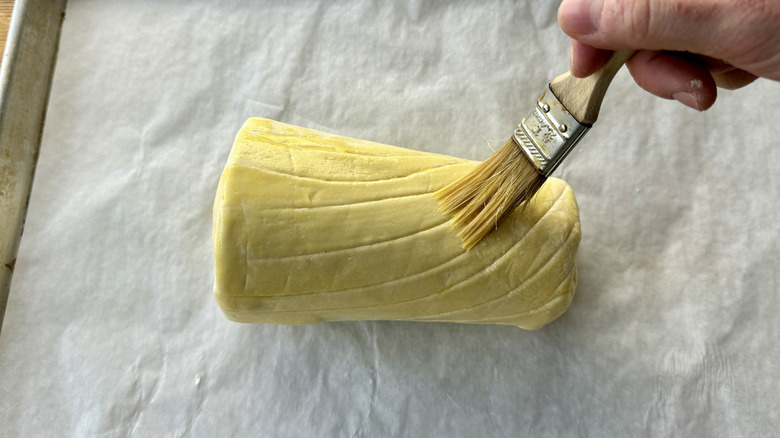 brushing puff pastry-wrapped tenderloin with egg wash