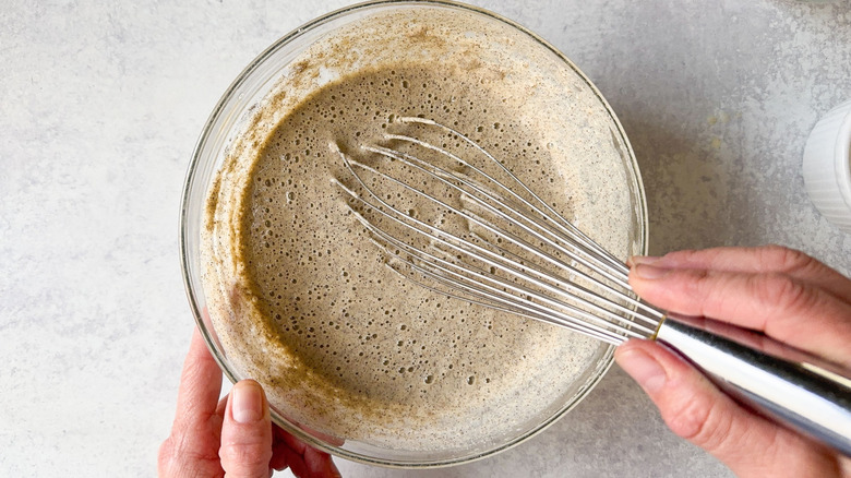 Whisking buckwheat crepe batter in glass bowl