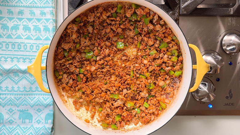 Ground turkey, green bell pepper, and spices in pot on stovetop