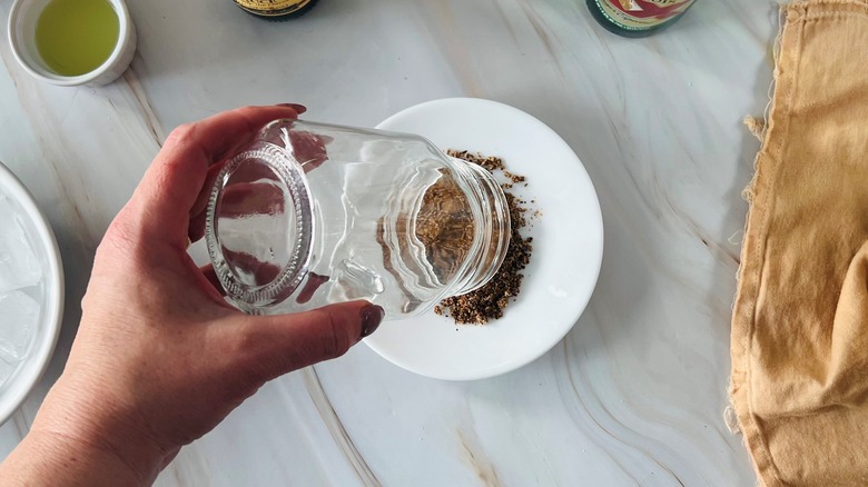 hand dipping glass in Tajin