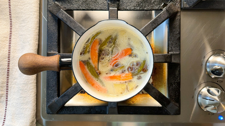 Hot chiles, ginger root, and vinegar simmering in saucepan on stovetop