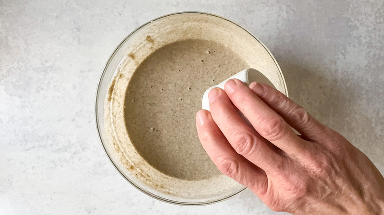 Pouring melted butter into buckwheat crepe batter