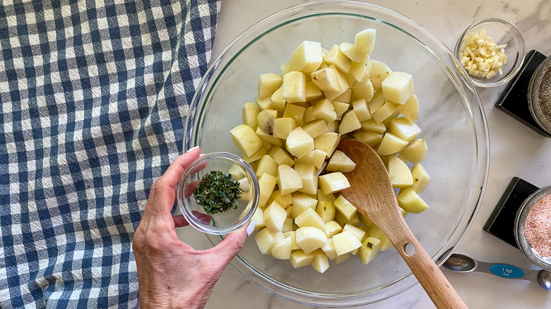 adding rosemary to bowl