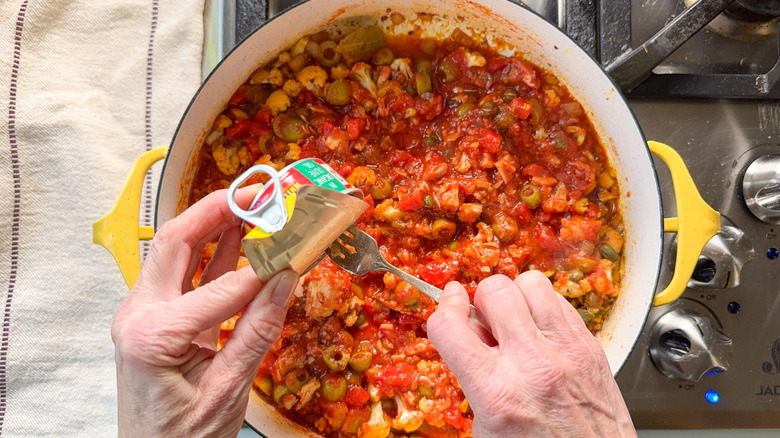 Adding tinned tuna to romesco-y sauce in pot on stovetop