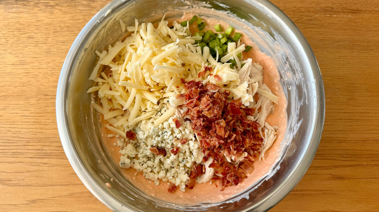Cheese, bacon bits, and green onions in dip bowl