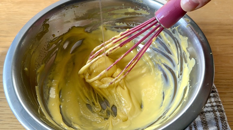 Slowly whisking oil into aioli