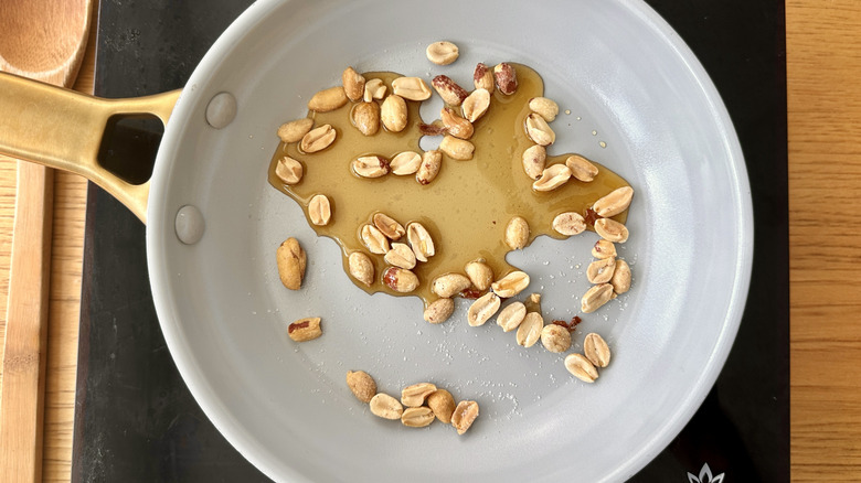 Maple syrup and peanuts in a skillet
