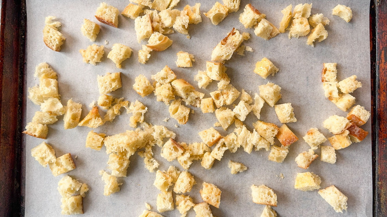 Bread cubes on parchment-lined baking sheet
