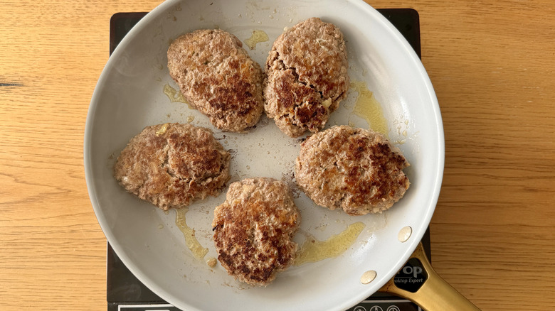 Salisbury steaks cooking in skillet