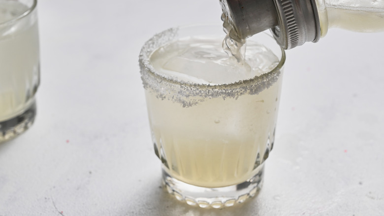 straining cocktail into glass