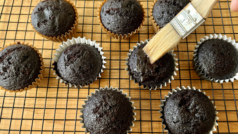 Brushing chocolate cupcakes with stout