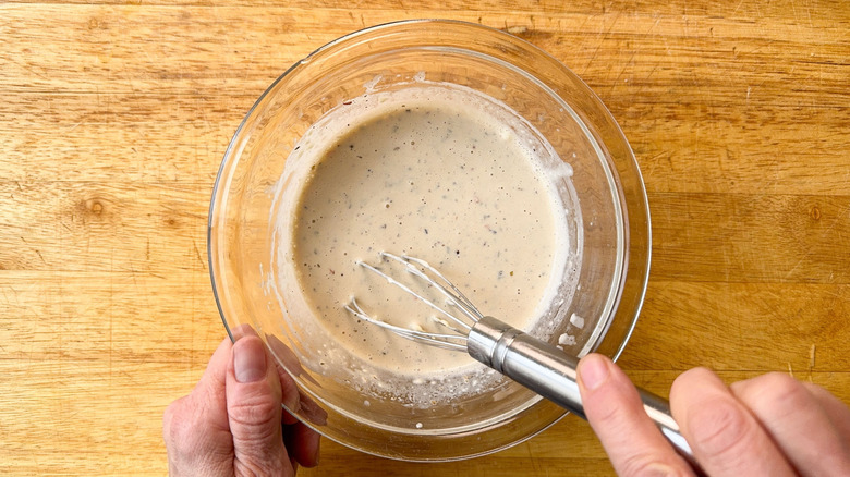 Whisking Italian deli grinder salad dressing in glass bowl