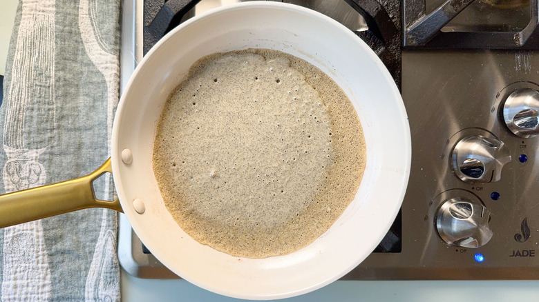 Buckwheat crepe cooking in pan on stovetop