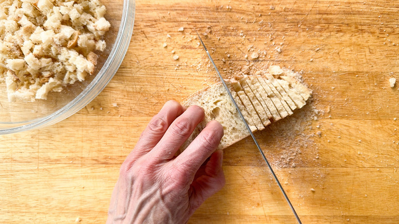 Cutting toasted ciabatta bread on cutting board