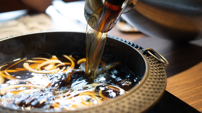 sukiyaki broth pouring into pot