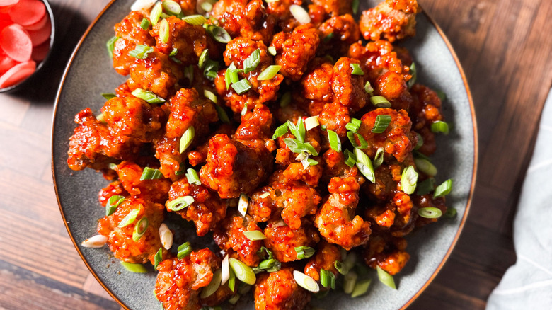 Sweet and spicy Korean fried popcorn chicken on serving platter with pickled radishes