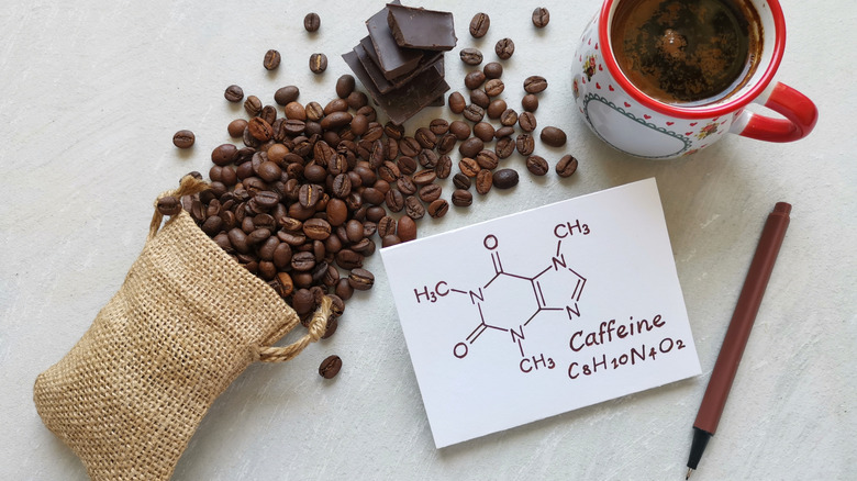 spilled coffee beans with the chemical formula for caffeine