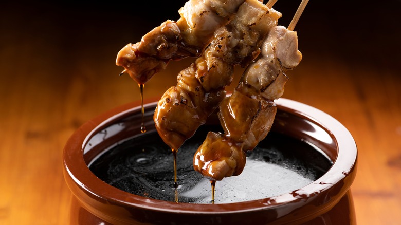yakitori skewers dipping into tare