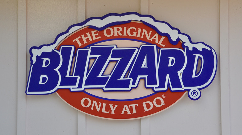 A red and blue marketing sign for Dairy Queen stating "The Original Blizzard Only at DQ"