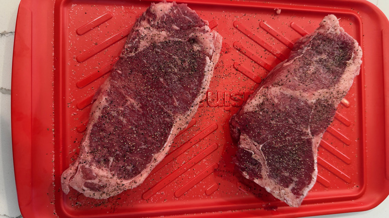 two uncooked strip steaks