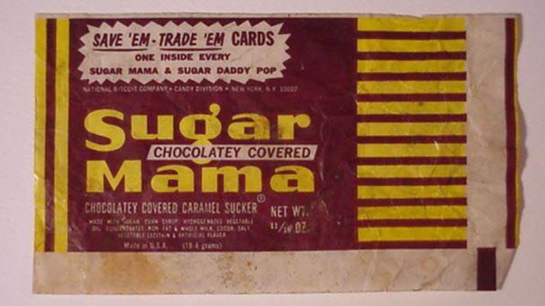 A maroon and yellow wrapper from a piece of Sugar Mama candy