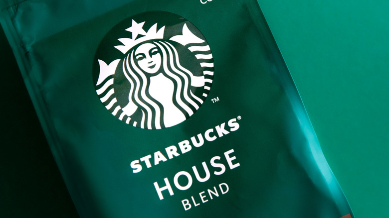 A green bag of Starbucks coffee on a light green background