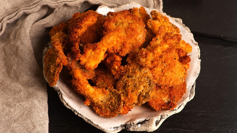A bowl full of breaded fried oysters.