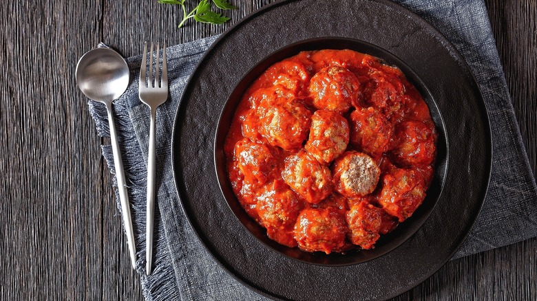 Iowa ham balls on a black plate over a grey cloth napkin