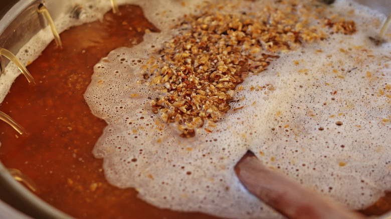 Person stirring a mash in kettle